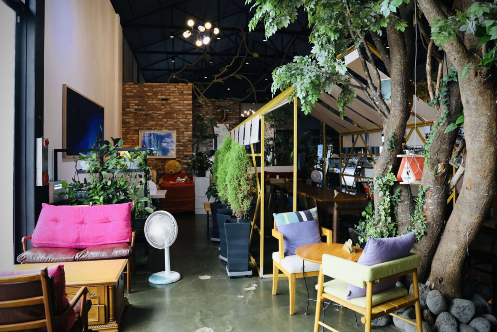 소파와 파빌리온 식물이 어우러져 있는 릴869 카페의 실내 모습